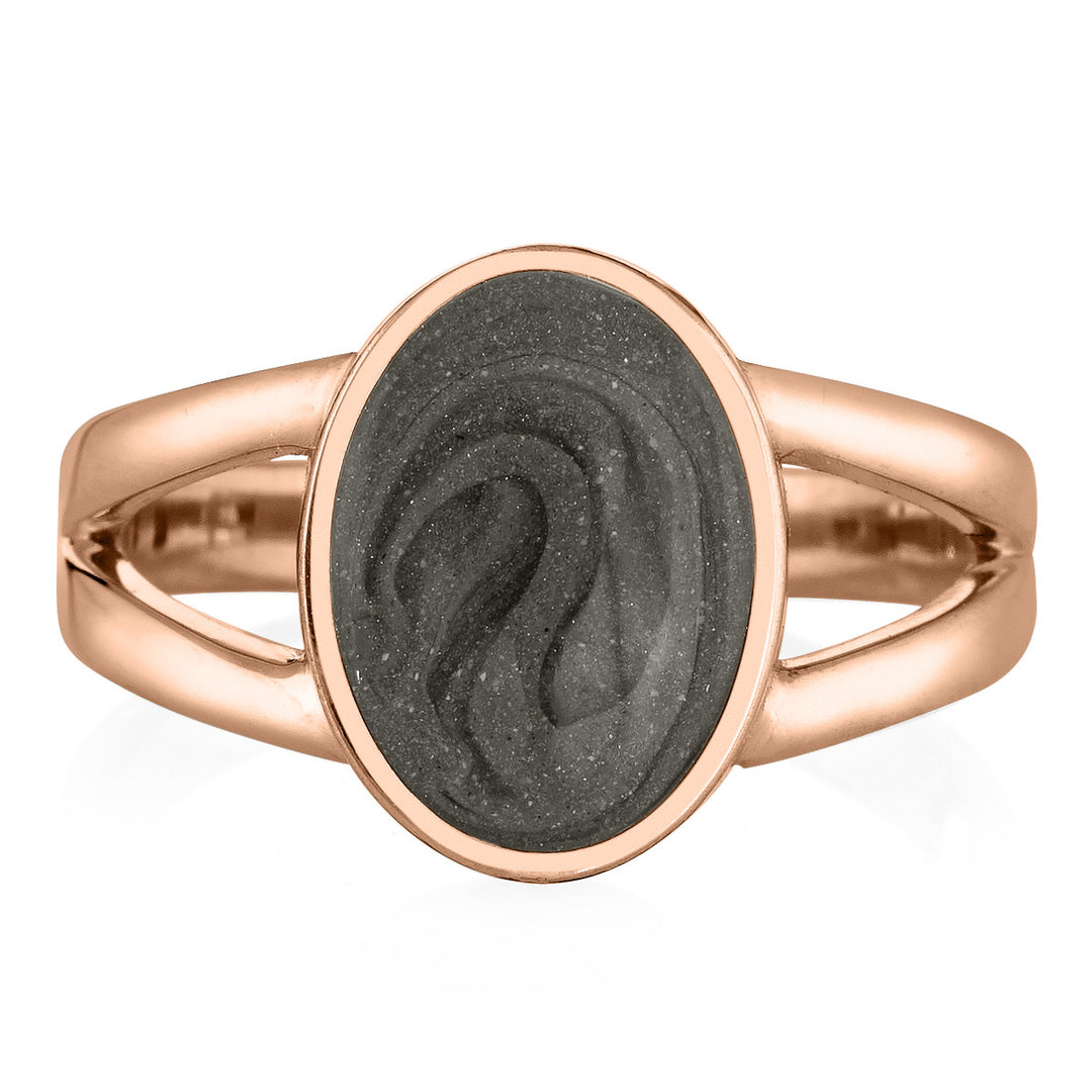 Pictured here is close by me jewelry's 14K Rose Gold Oval Split Shank Ashes Ring design from the front to show its medium grey cremation setting and split band