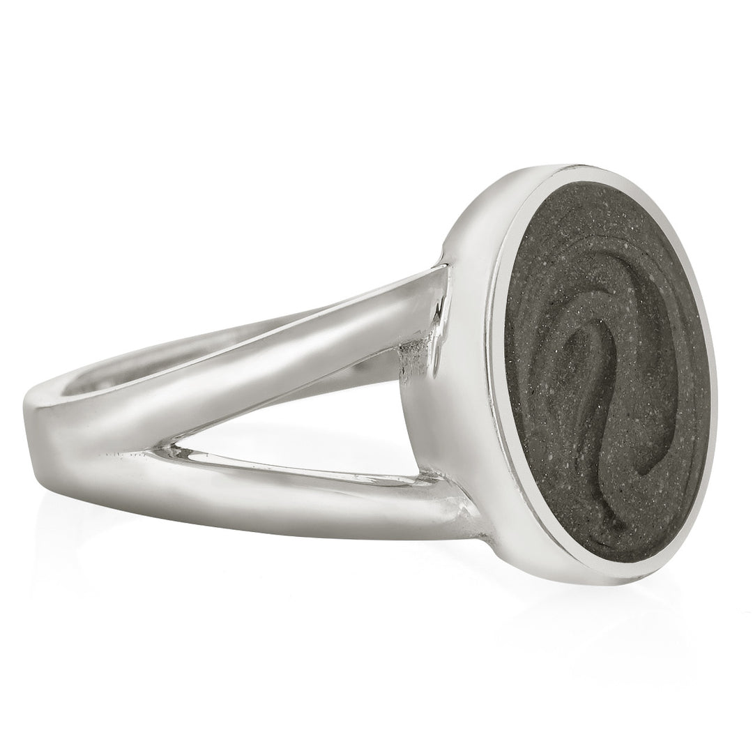 Pictured here is close by me jewelry's Sterling Silver Oval Split Shank Ashes Ring design from the side to show its medium grey cremation setting, thickness of its bezel, and split band
