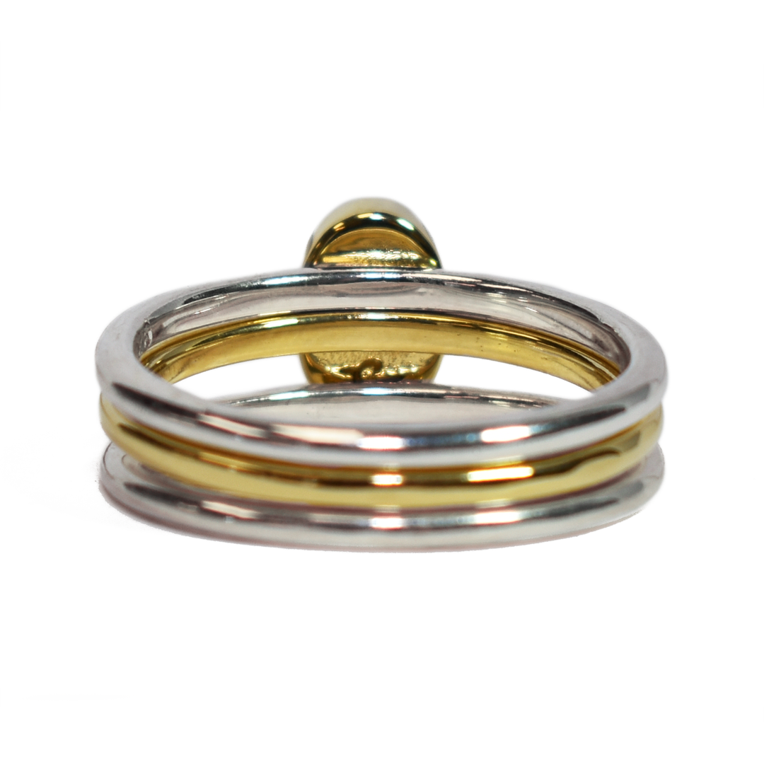 This photo shows the Mixed Metal Stacking Cremation Ring set designed by close by me jewelry with a 14K Yellow Gold Oval Stacking Ring with ashes between two Sterling Silver Smooth Companion Rings from the back