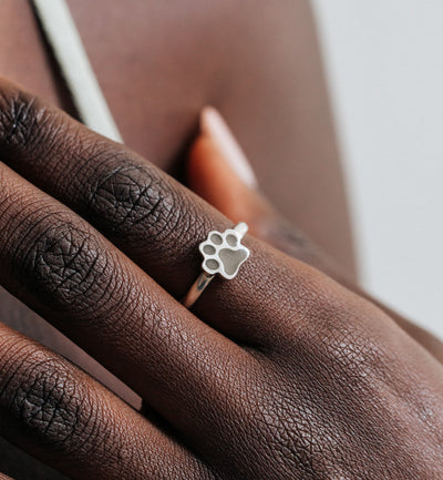 This is a close up of a model wearing close by me jewelry's Paw Print Stacking Ashes Ring in Sterling Silver on her index finger