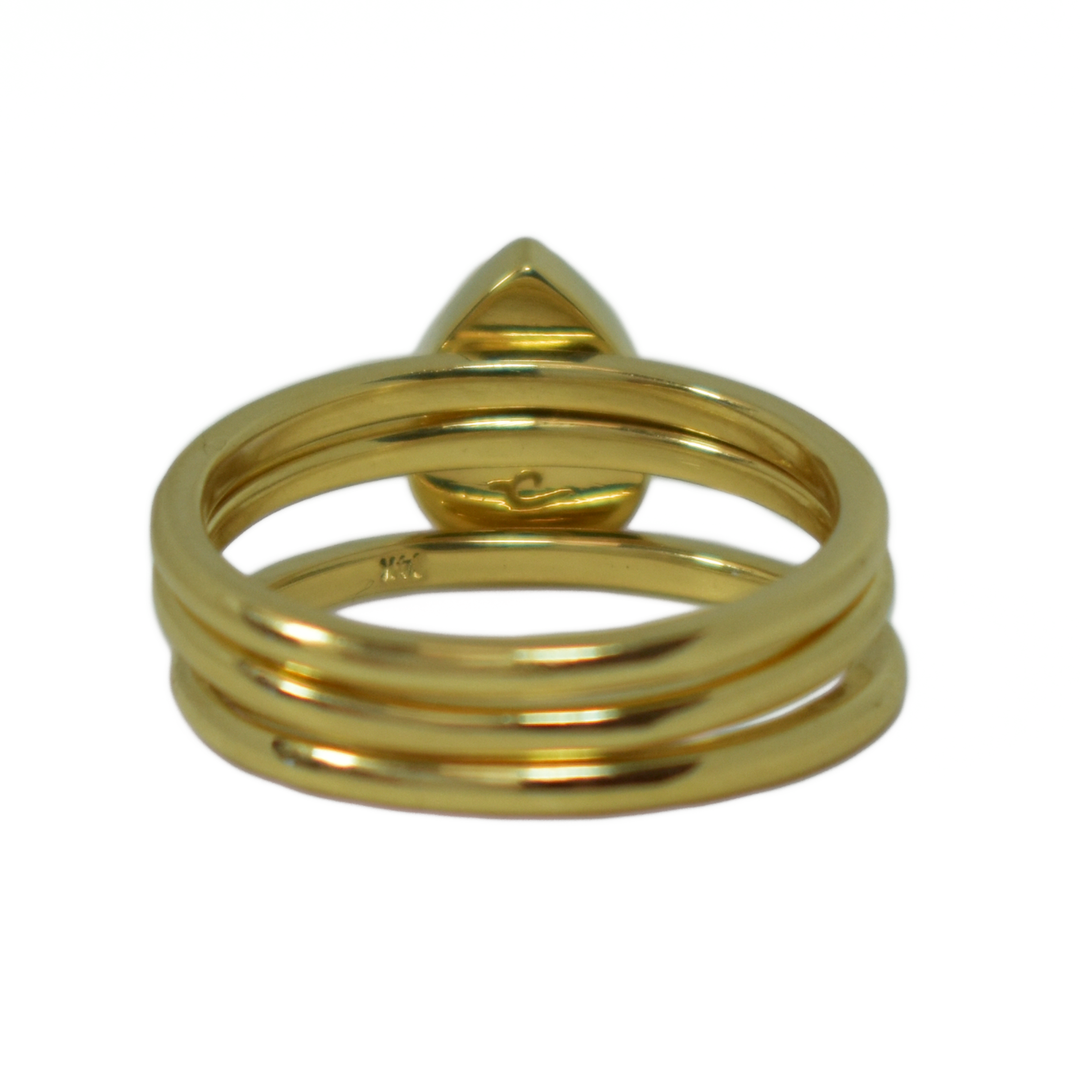 This photo shows a stacking set in 14K Yellow Gold with a Pear Ashes Stacking Ring in the center, designed by close by me jewelry, from the back