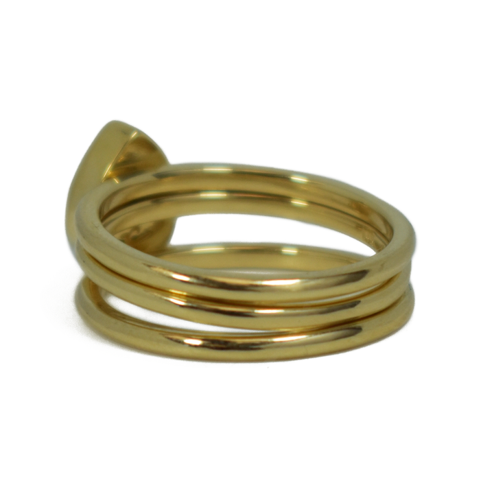This photo shows a stacking set in 14K Yellow Gold with a Pear Ashes Stacking Ring in the center, designed by close by me jewelry, from the back at an angle to the left