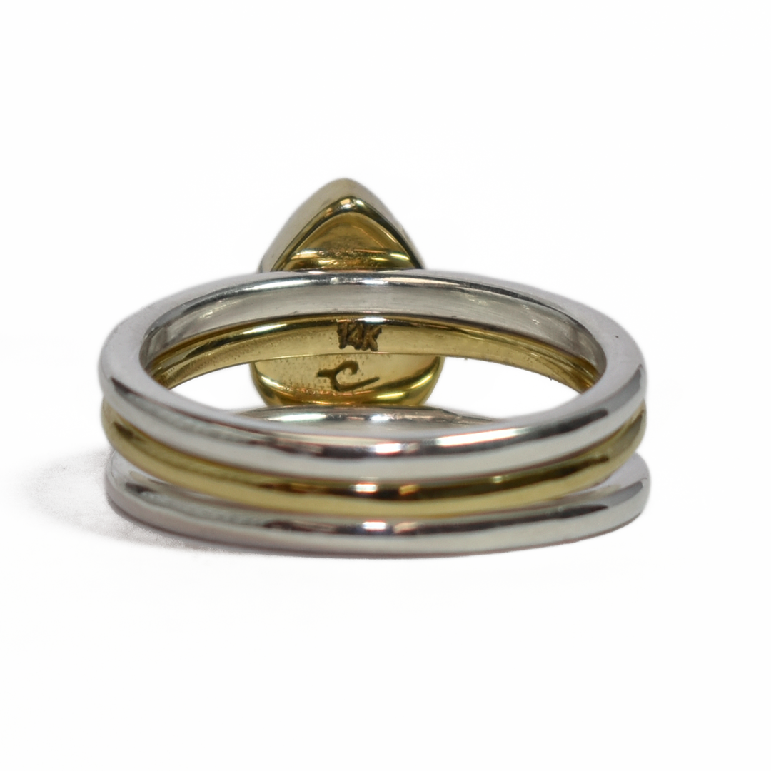 This photo shows close by me jewelry's mixed metal stacking set with a Pear Ashes Stacking Ring in 14K Yellow Gold and two Sterling Silver Smooth Companion Rings from the back
