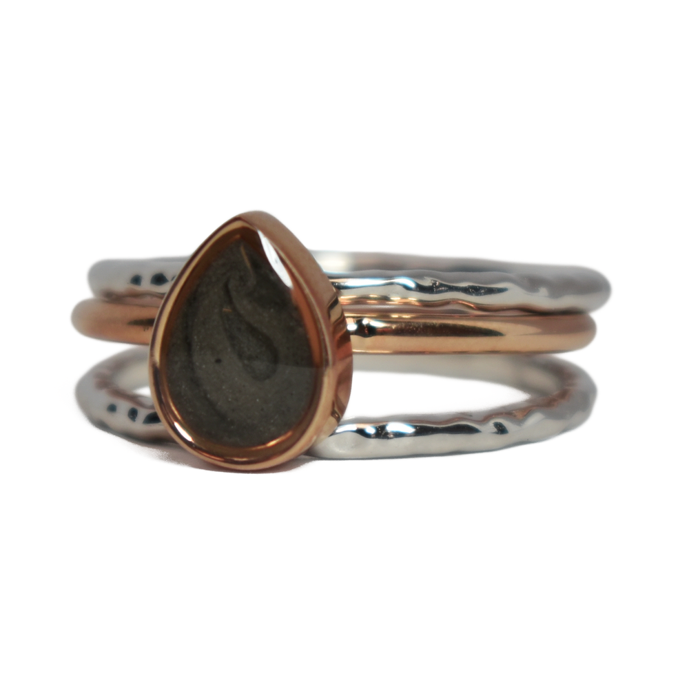 This photo shows the Pear Cremation Stacking Ring in 14K Rose Gold paired with two 14K White Gold Textured Companions to create one of close by me jewelry's ashes stacking ring sets from the front at an angle to the left