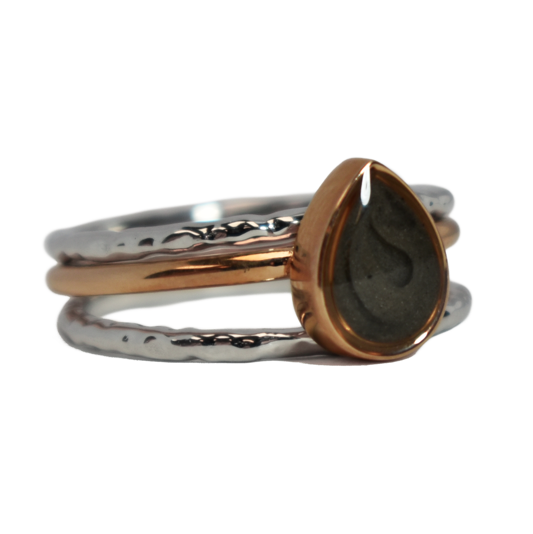 This photo shows the Pear Cremation Stacking Ring in 14K Rose Gold paired with two 14K White Gold Textured Companions to create one of close by me jewelry's ashes stacking ring sets from the front at a slight angle to the right