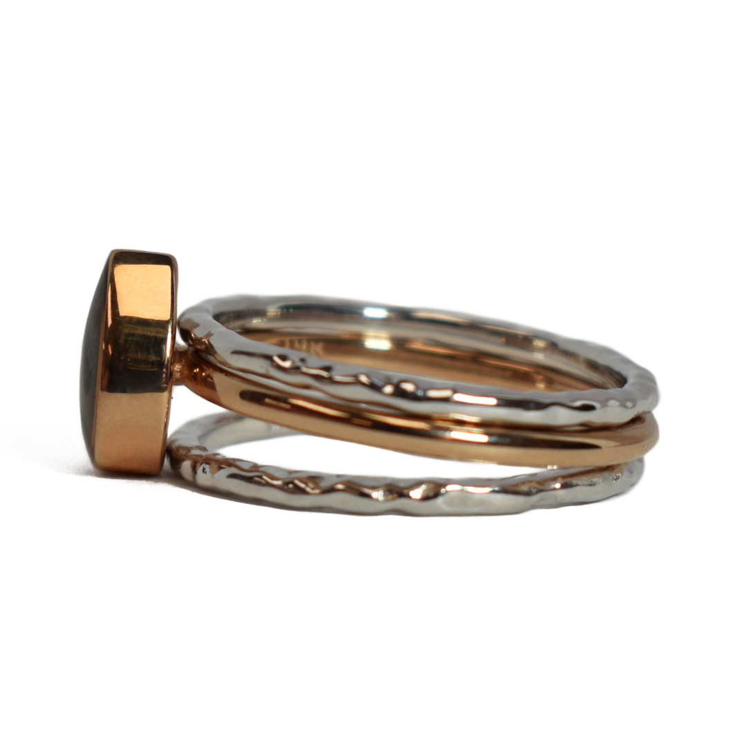 This photo shows the Pear Cremation Stacking Ring in 14K Rose Gold paired with two 14K White Gold Textured Companions to create one of close by me jewelry's ashes stacking ring sets from the side