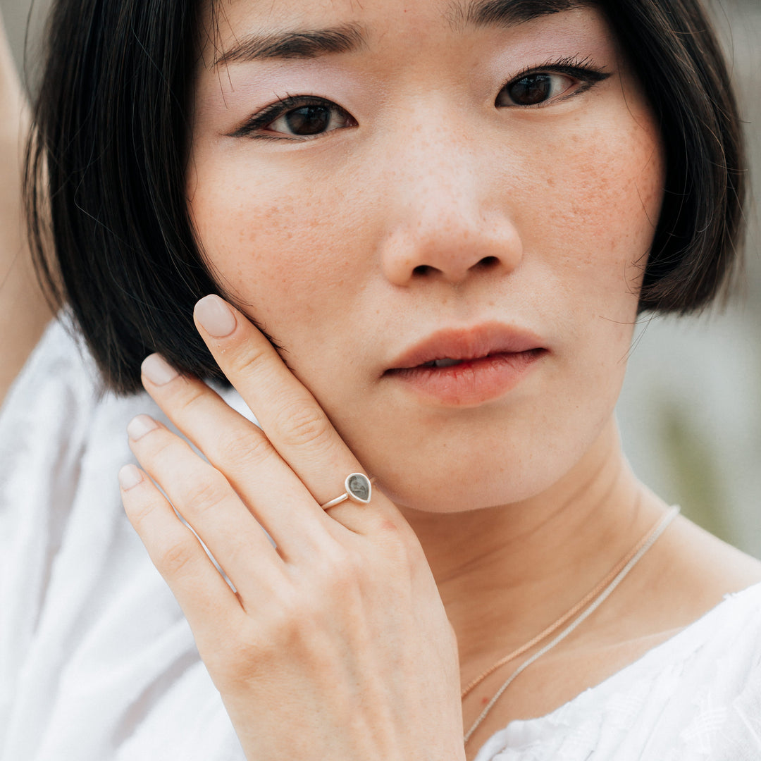 This photo shows a model posing with close by me jewelry's Sterling Silver Pear Stacking Ring on her finger