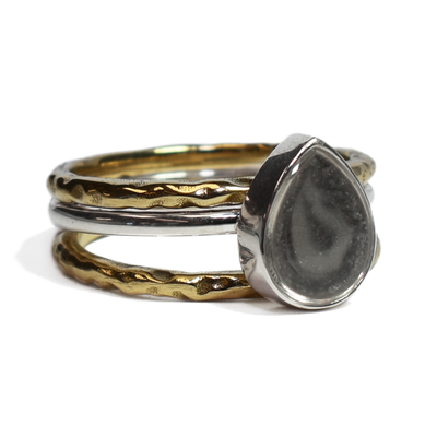 This photo shows the Pear Stacking Ashes Ring Set in Sterling Silver with two 14K Yellow Gold Companion Rings to create a stacking set by close by me jewelry from the right side