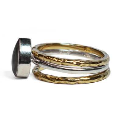 This photo shows the Pear Stacking Ashes Ring Set in Sterling Silver with two 14K Yellow Gold Companion Rings to create a stacking set by close by me jewelry from the left side