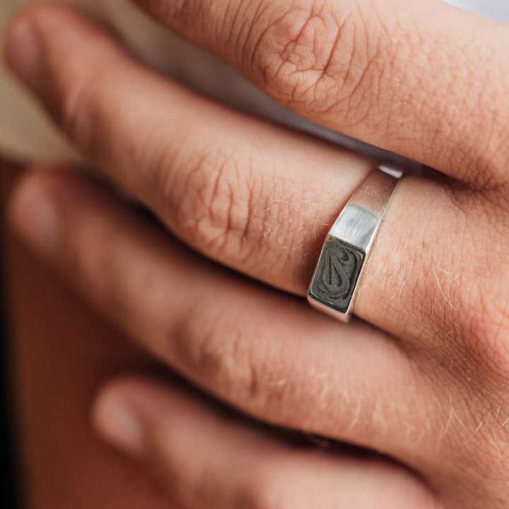 Pictured here is a close up of a male model wearing the Sterling Silver Men's Rectangle Signet Cremation Ring design by close by me jewelry
