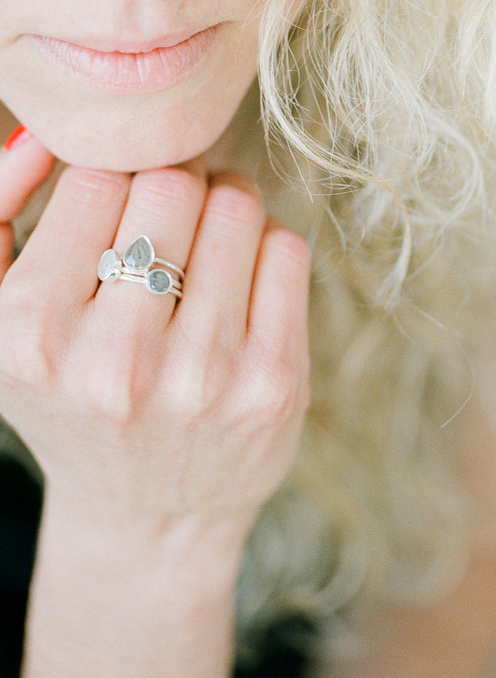 This photo shows a model wearing three shapes of settings in close by me jewelry's Stacking Ashes Ring sets in Sterling Silver