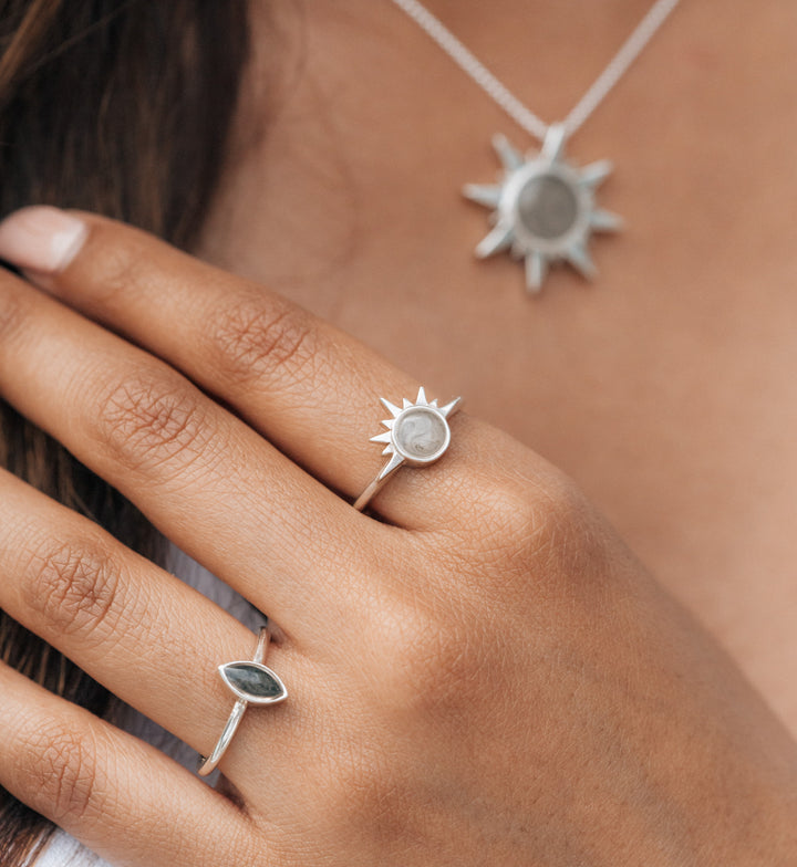 This photo shows a model wearing the Sun Pendant and Sunrise Ring with cremains designed by close by me jewelry in Sterling Silver