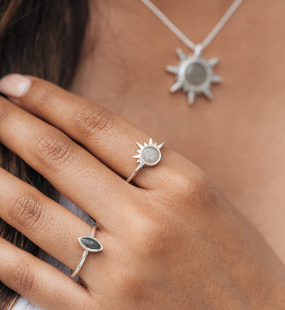 Pictured here is the Sterling Silver Sunrise Cremation Ring on a model's finger alongside other Silver jewelry designed by close by me jewelry