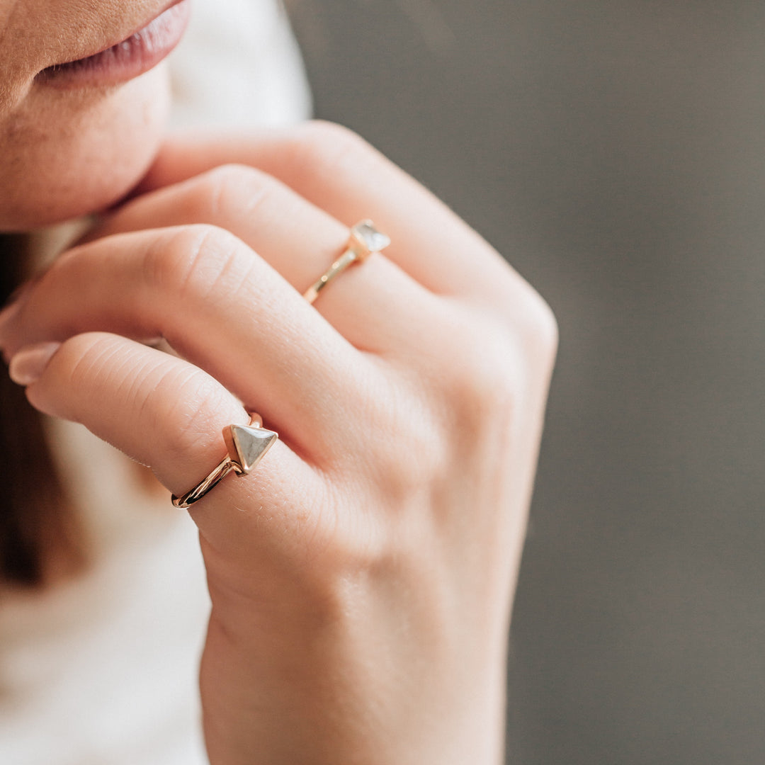 This photo shows the 14K Rose Gold Triangle Stacking Cremains Ring, designed by close by me jewelry, on a model's pinky finger