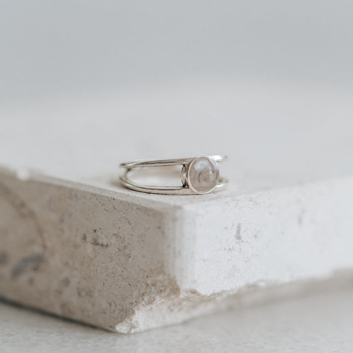 Pictured here is the Sterling Silver Twin Band Ashes Ring designed by close by me jewelry lying flat on a stone
